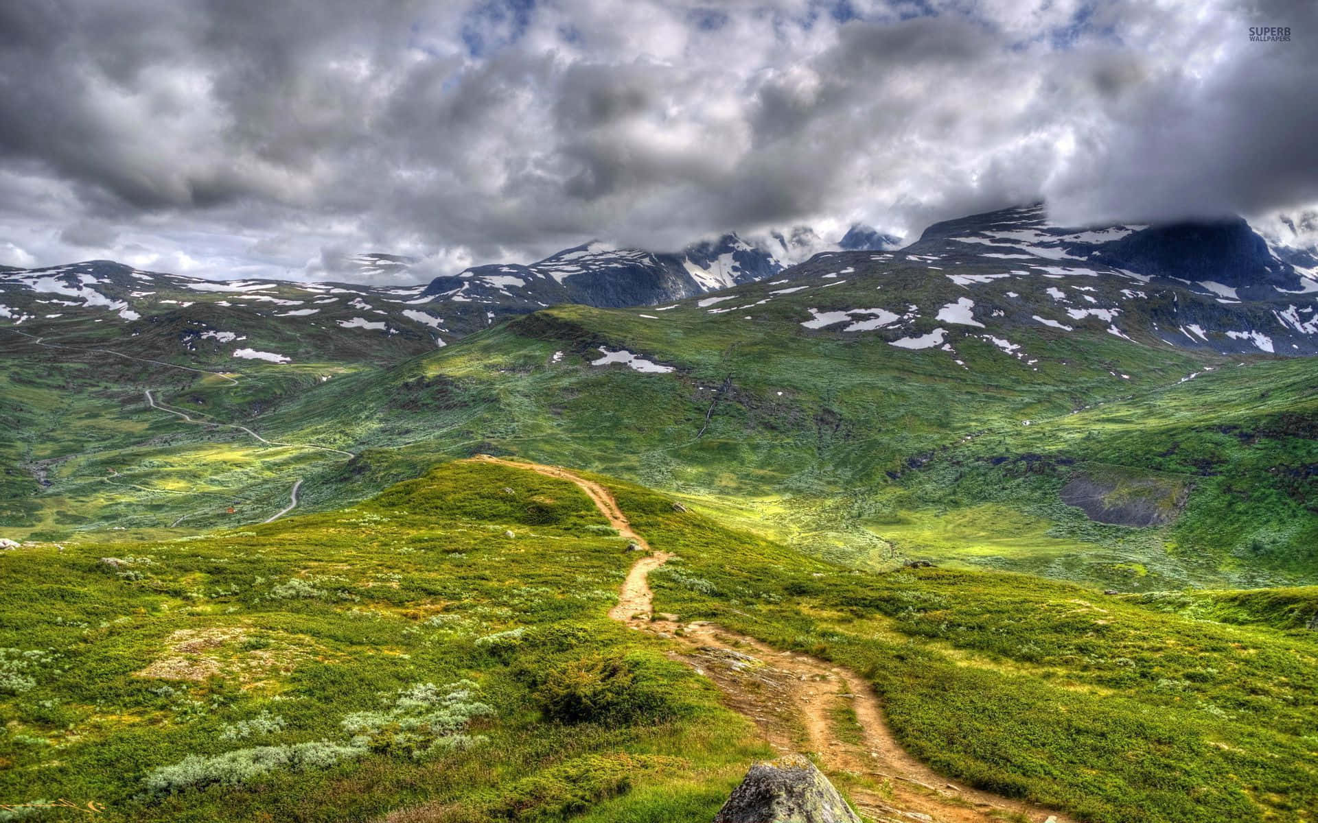 Dirt Road Passing Through The Mountain Background