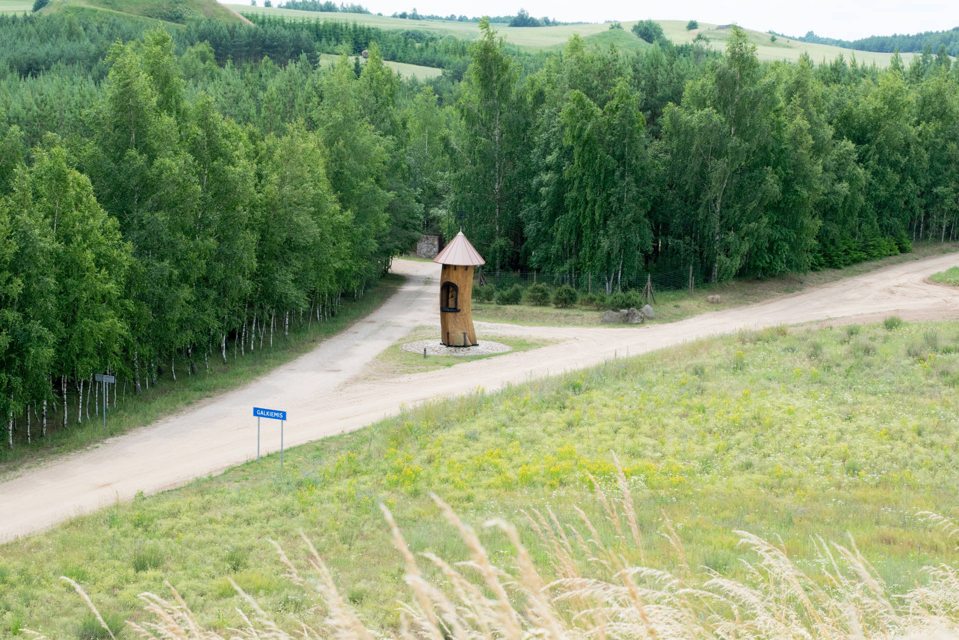 Dirt Road With Wooden Tower In Lithuania Background