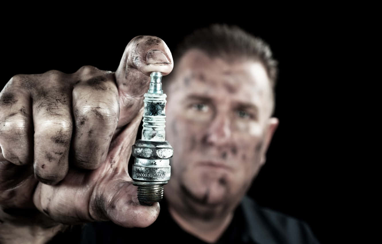 Dirty Man Holding Spark Plug Background