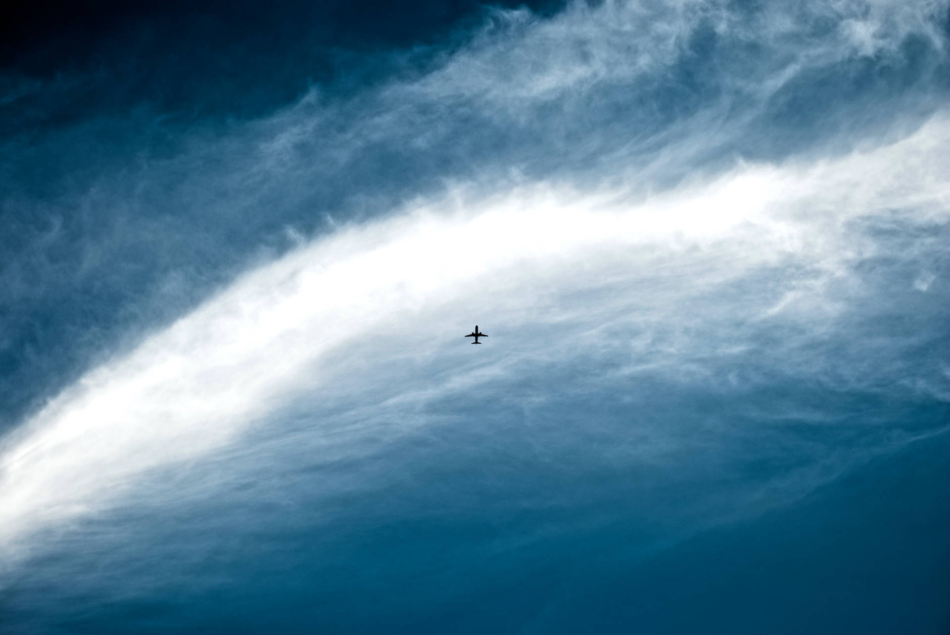 Distant Plane In Vast Sky Background