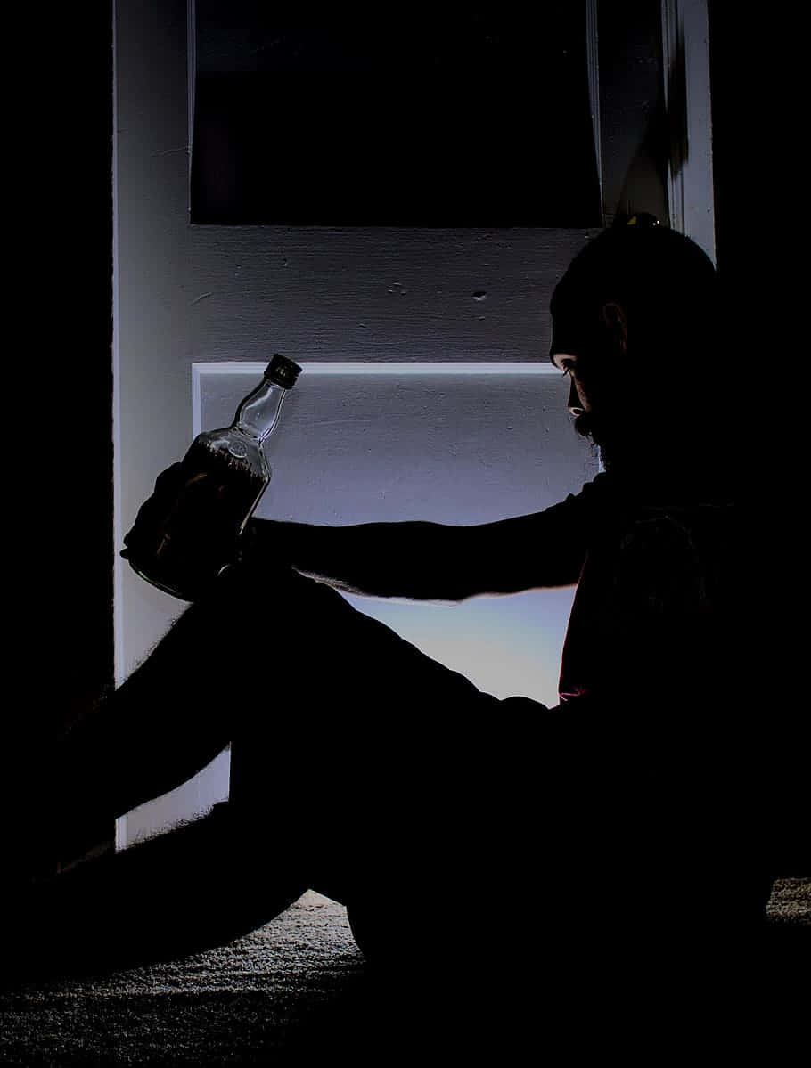 Distressed Man Coping Through Alcohol Background
