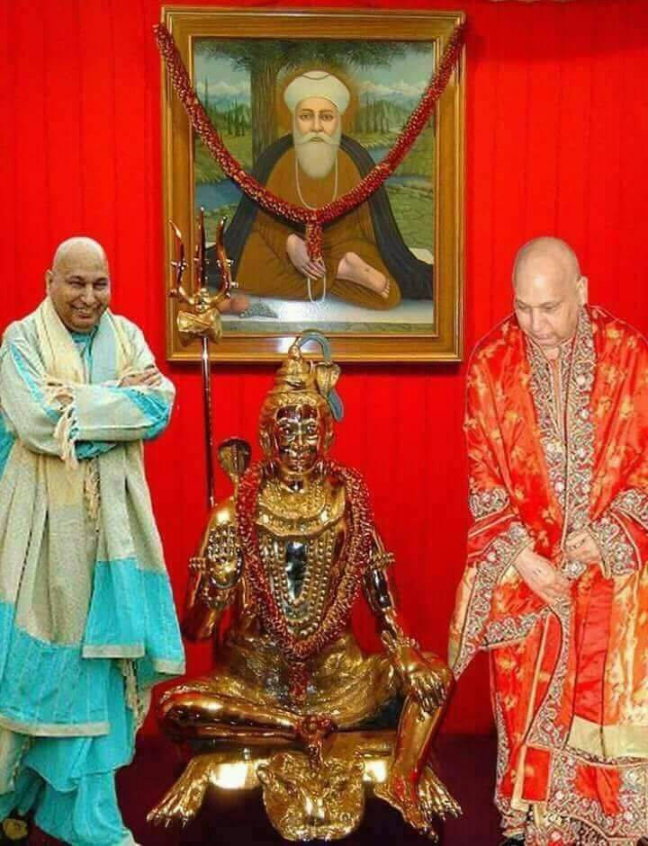 Divine Encounter: Guru Ji Engaging In Deep Spiritual Commune With Hindu Deity Sculpture. Background