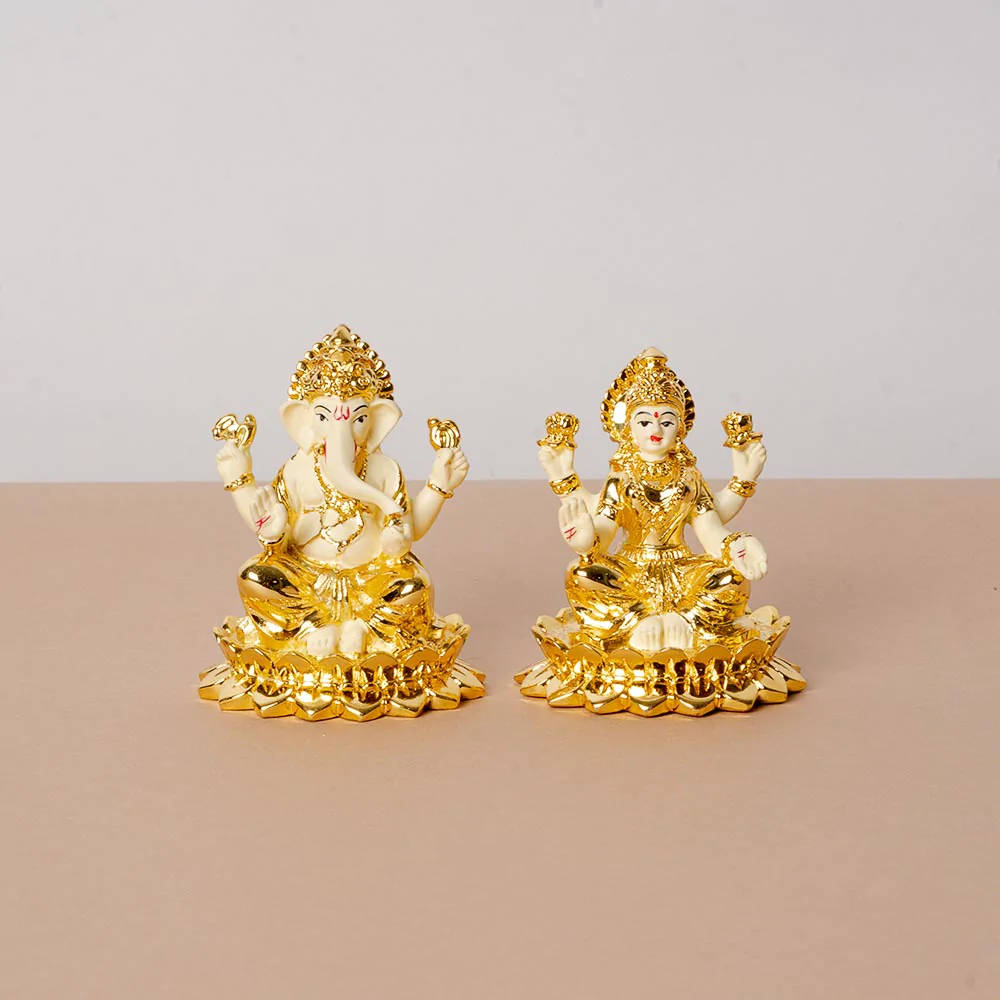 Divine Golden Statuettes Of Ganesh And Lakshmi Background
