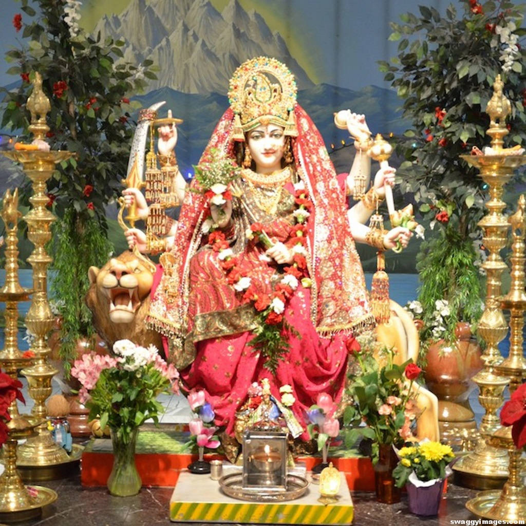 Divine Vaishno Devi Statue Adorned With Fresh Flowers Background