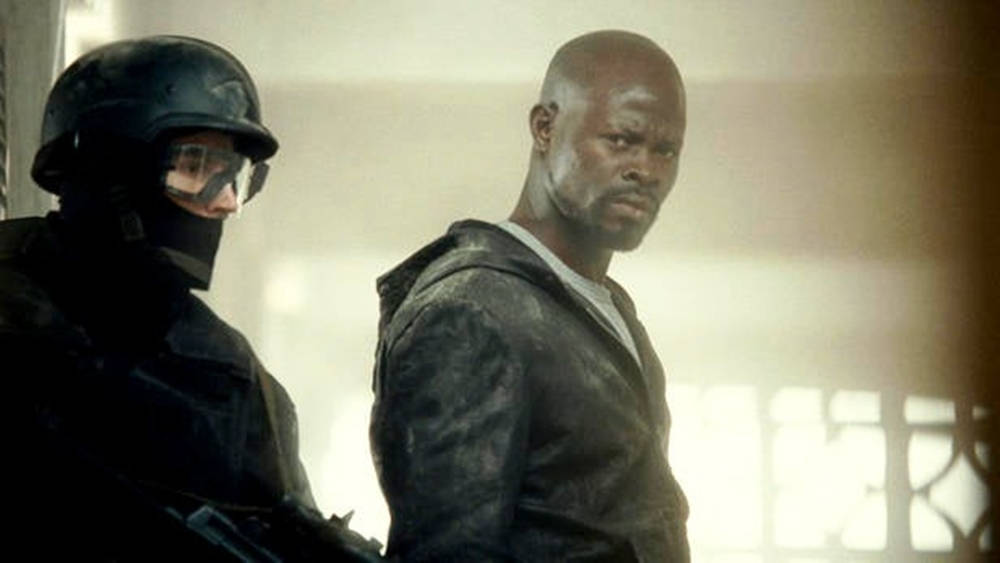 Djimon Hounsou With Armed Man Background