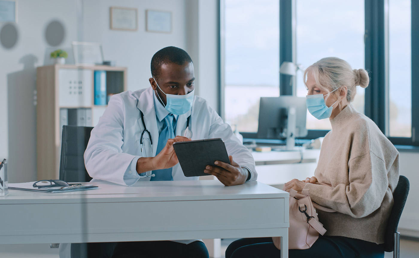 Doctor Consulting With Patient In Clinic Background