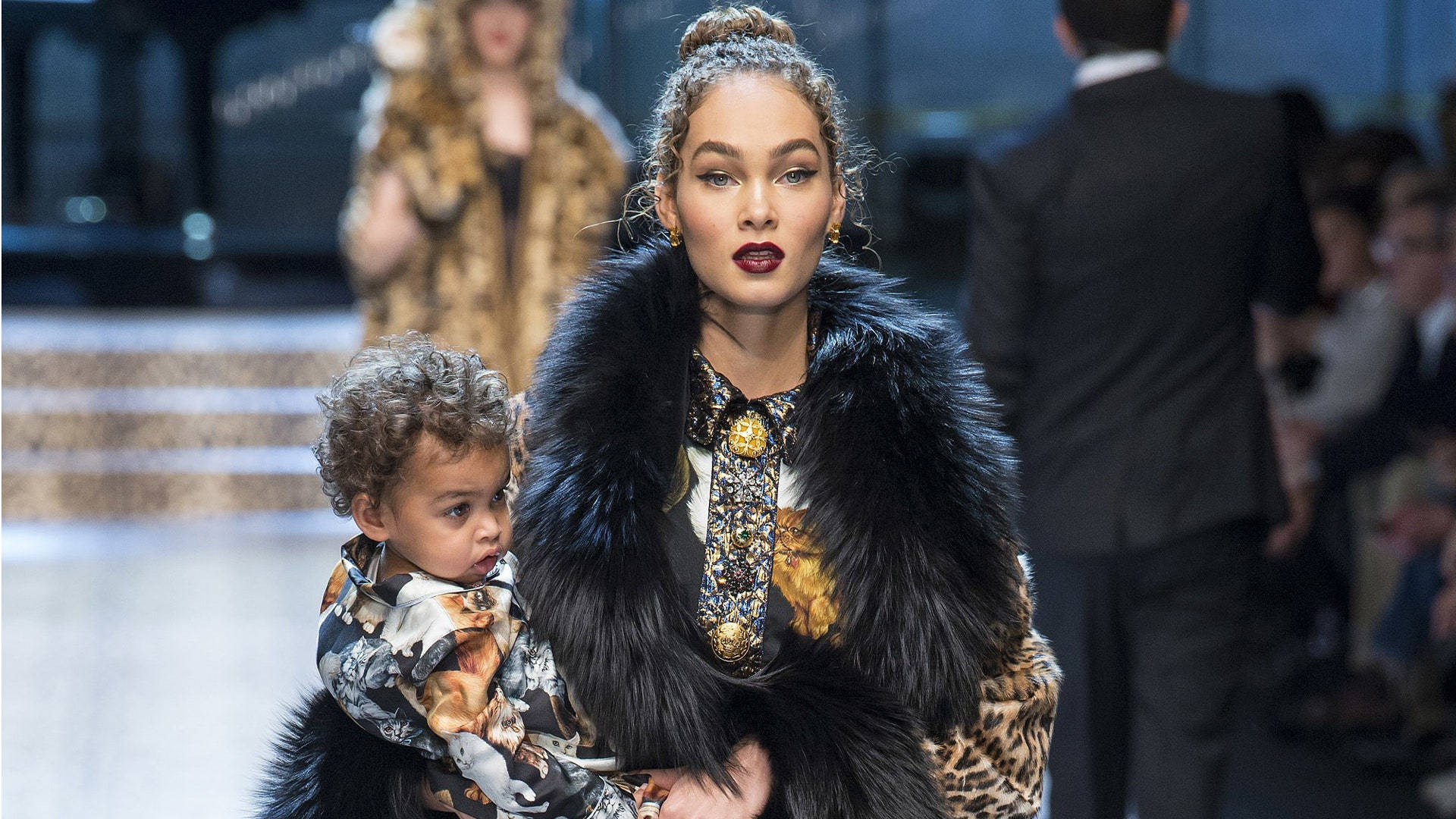 Dolce And Gabbana Model Holding A Child Background