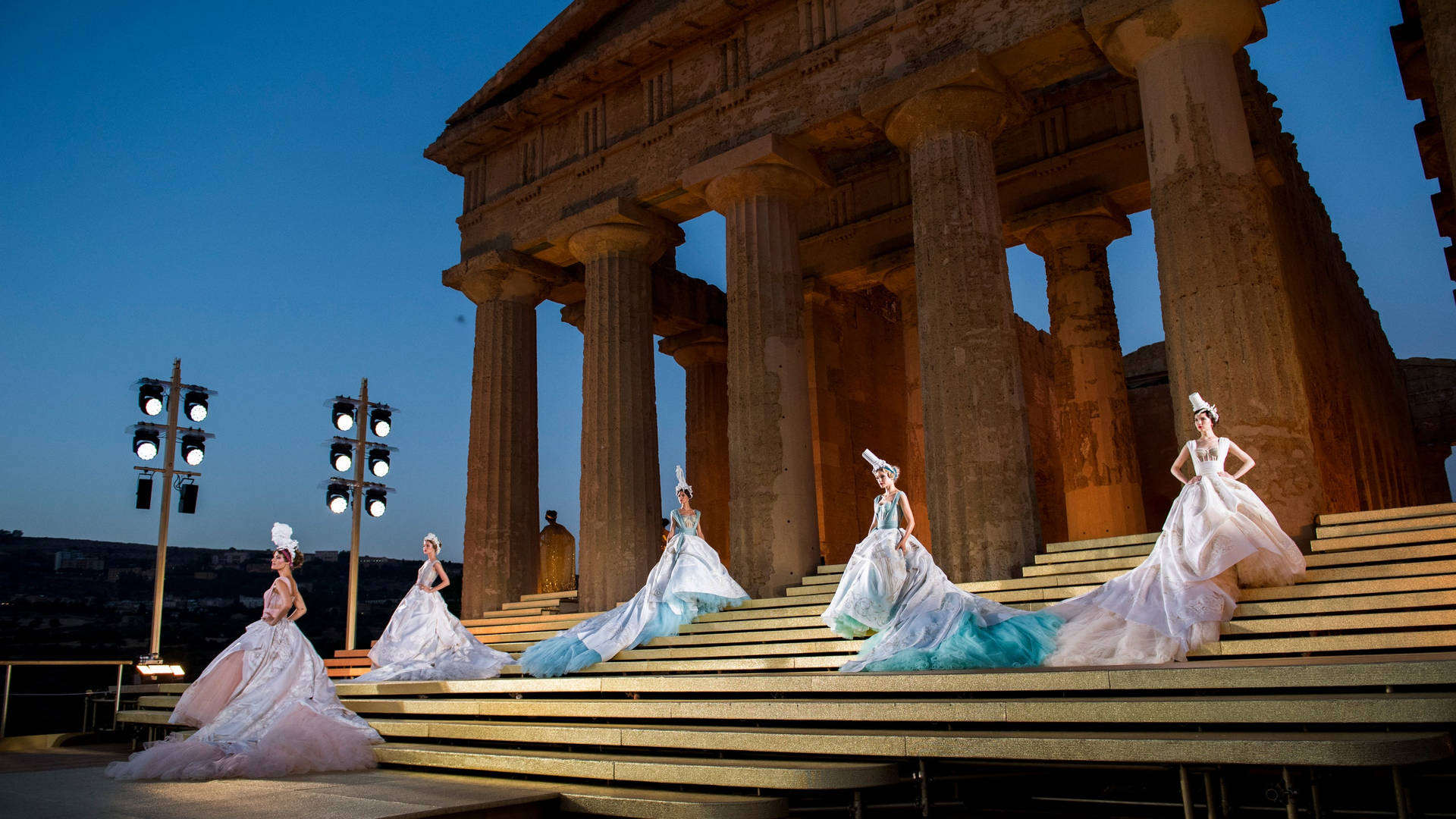 Dolce And Gabbana Models Sitting Beneath Pillars