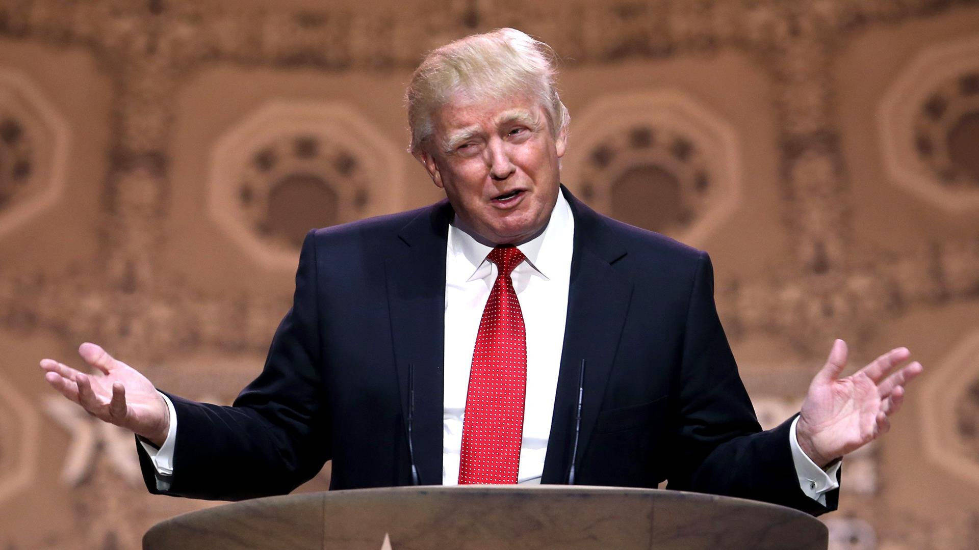 Donald Trump Speaking On A Podium Background