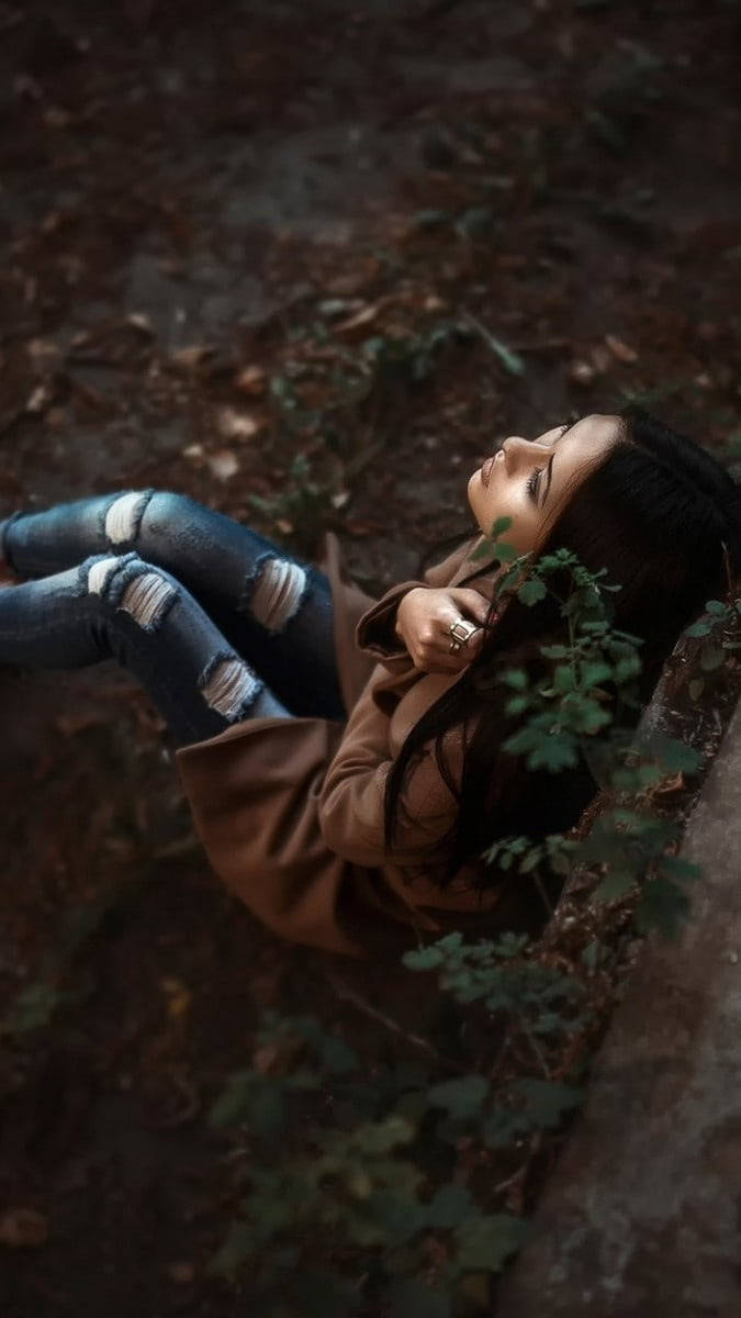 Dramatic Girl Sitting In Forest Alone Background