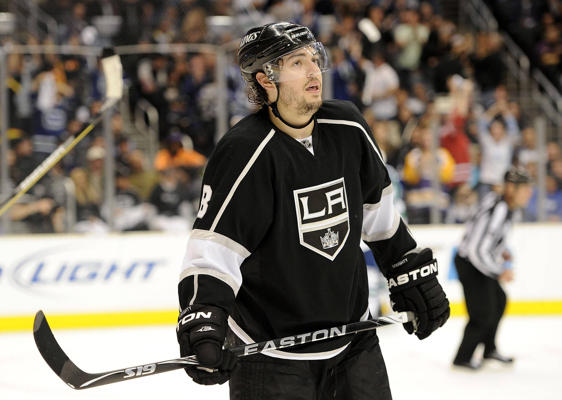 Drew Doughty Looking Up While Holding Hockey Stick Background