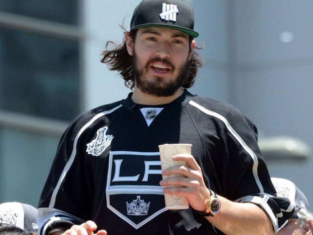 Drew Doughty Wearing Snapback Cap And Holding Large Cup Background