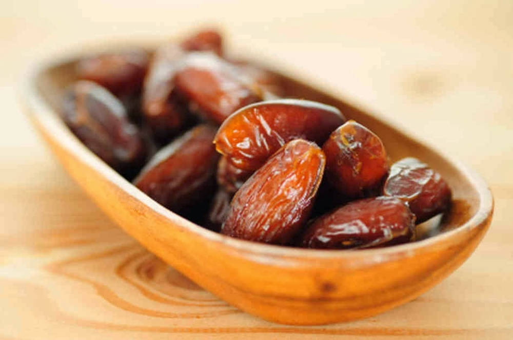 Dried Dates On A Wooden Plate Background