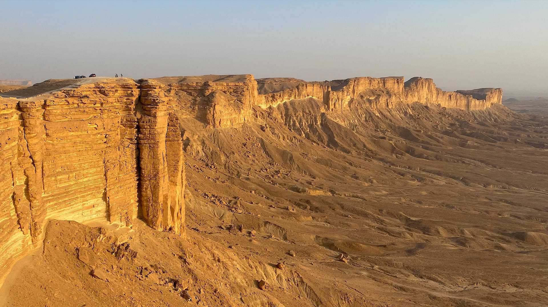 Dusk Falling Over The Majestic Jebel Fihrayn Cliffs In Saudi Arabia Background