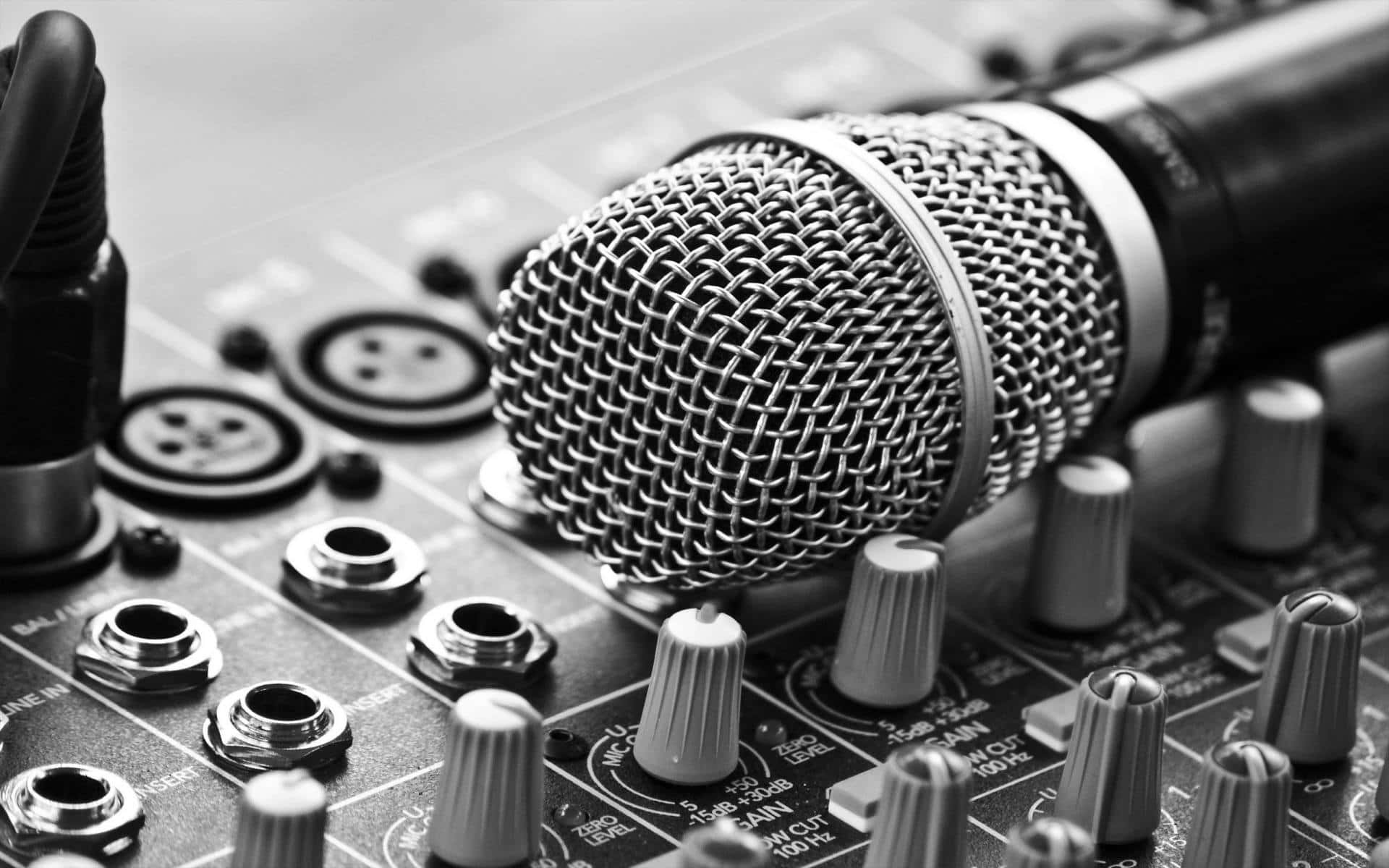 Dynamic Microphone On Top Of A Mixing Console Background