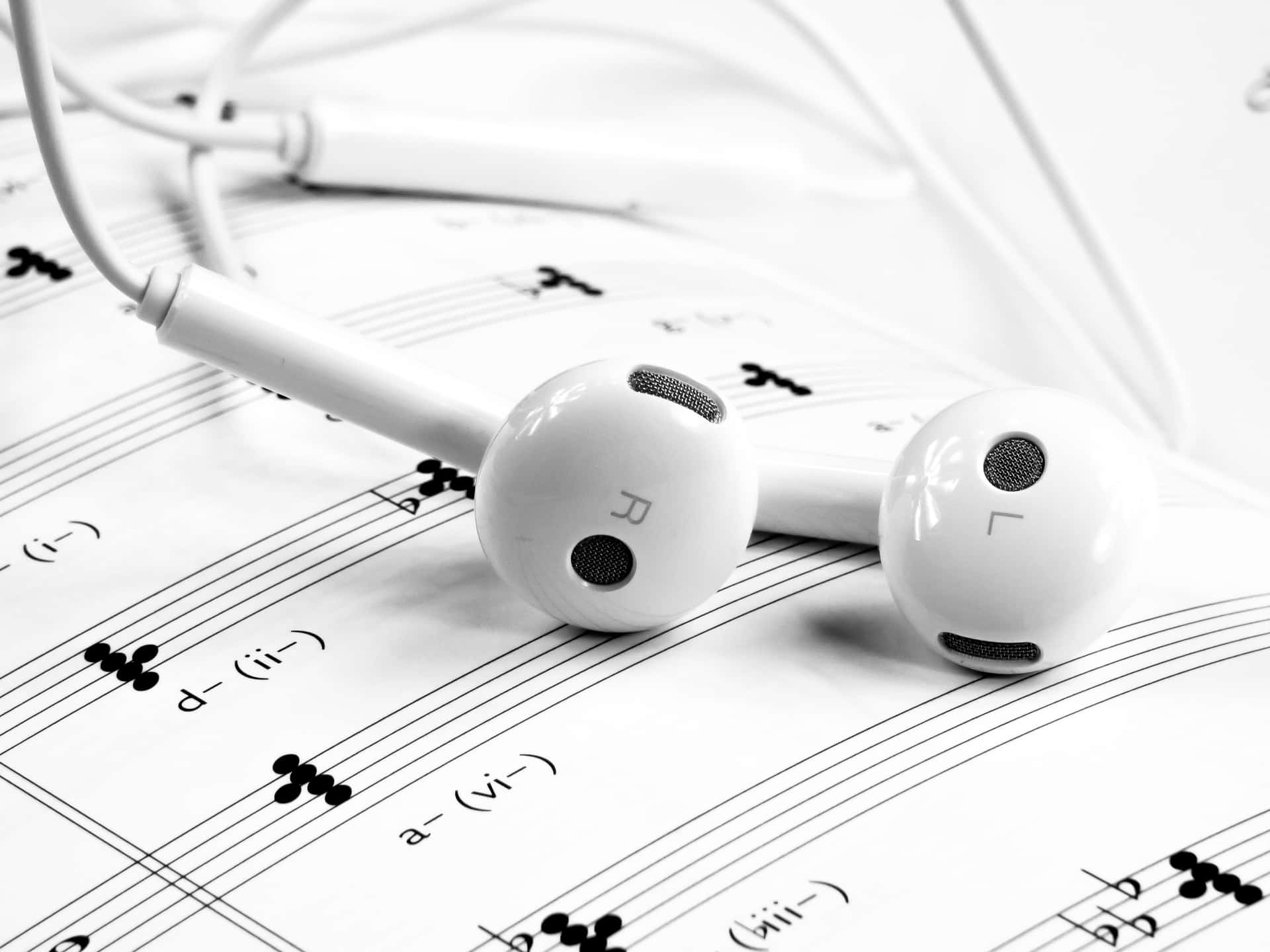 Earphones On Music Sheet With Music Notes Background