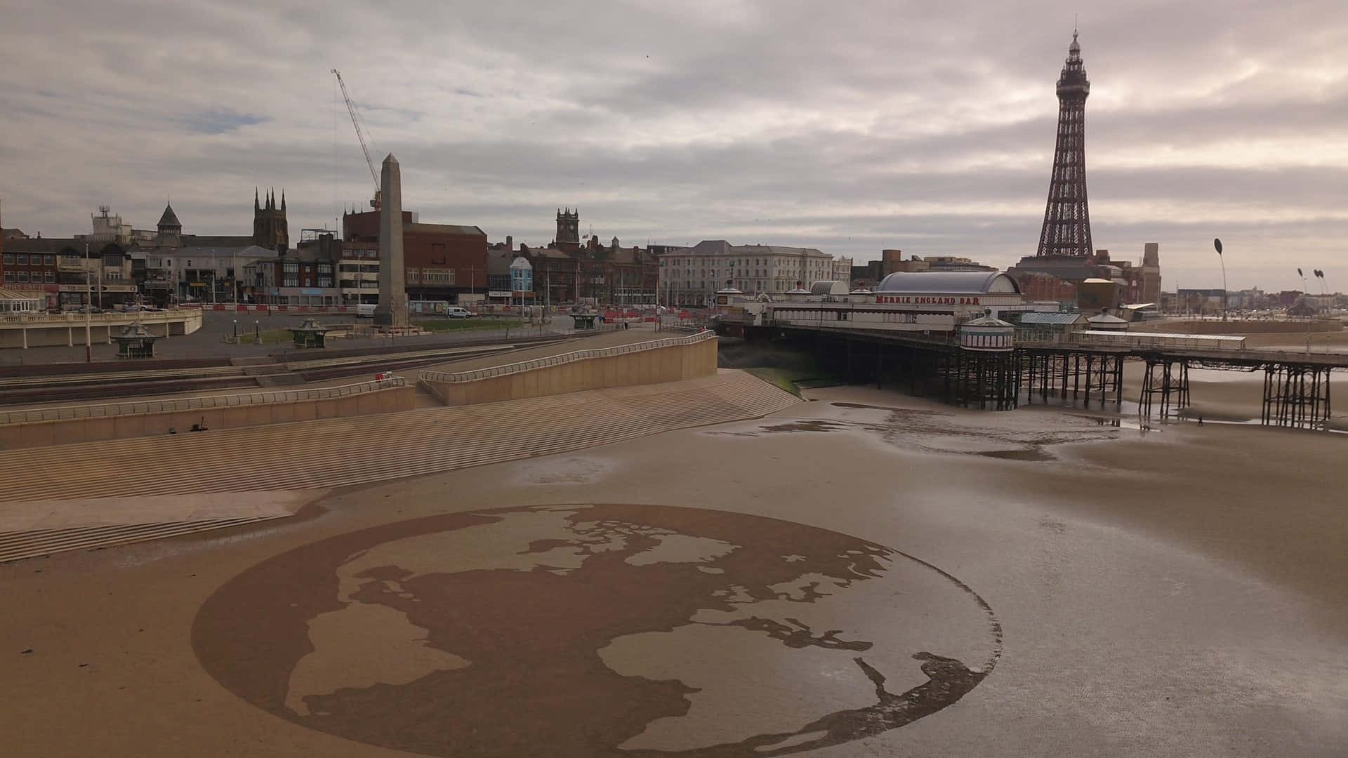 Earth Sculpture In The Sands Near The Iconic Blackpool Tower Background