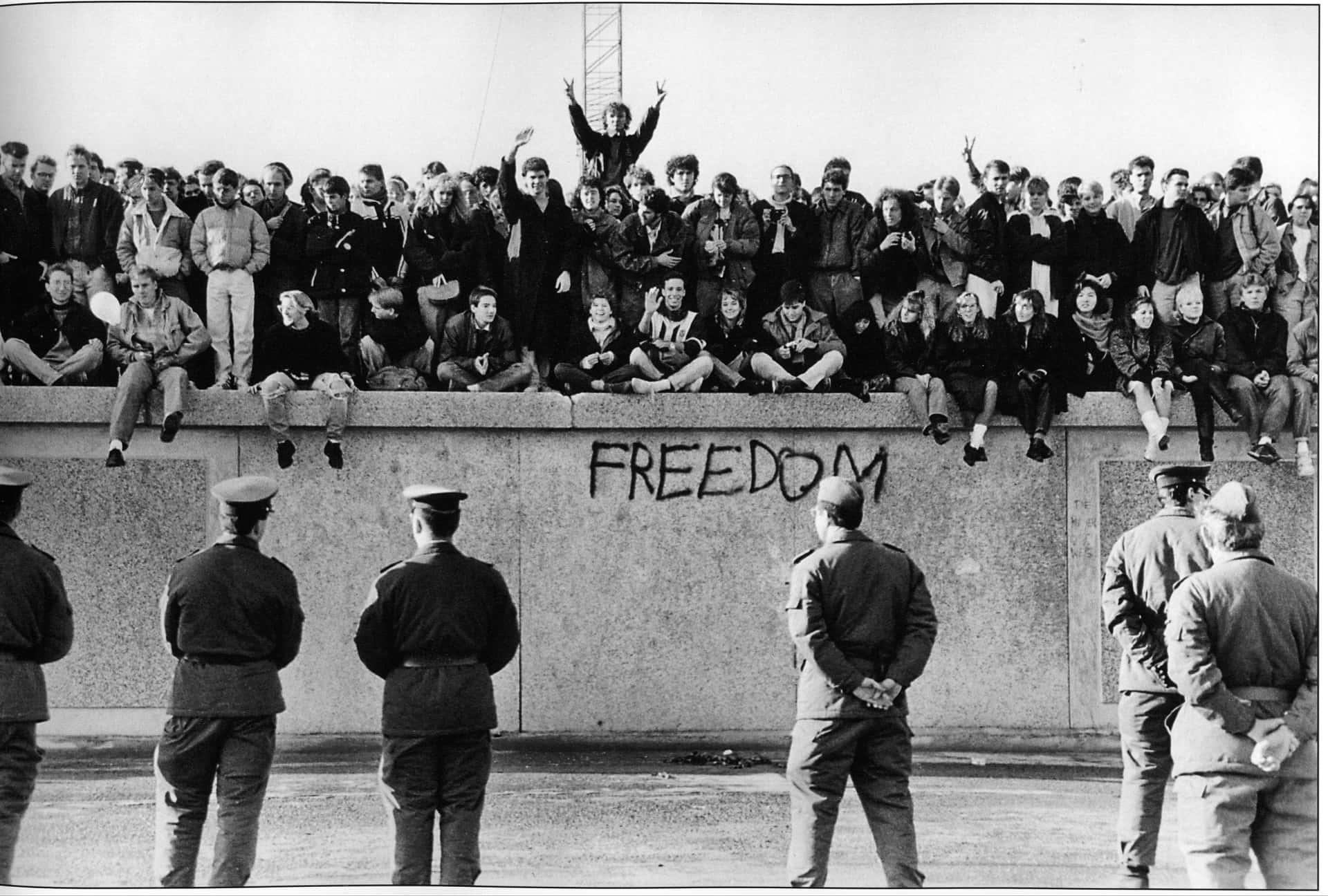 East German Students Celebrate Freedom Atop The Berlin Wall, 1989 Background