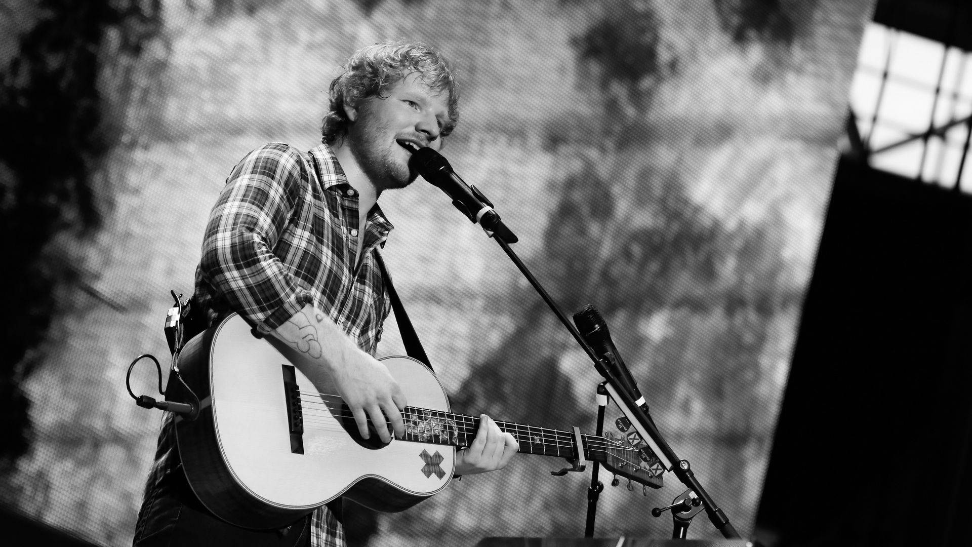 Ed Sheeran Performing On Stage Background