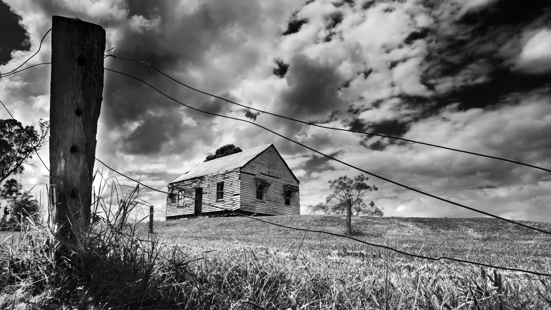 Eerie Haunted House Under A Cloudy Sky Background