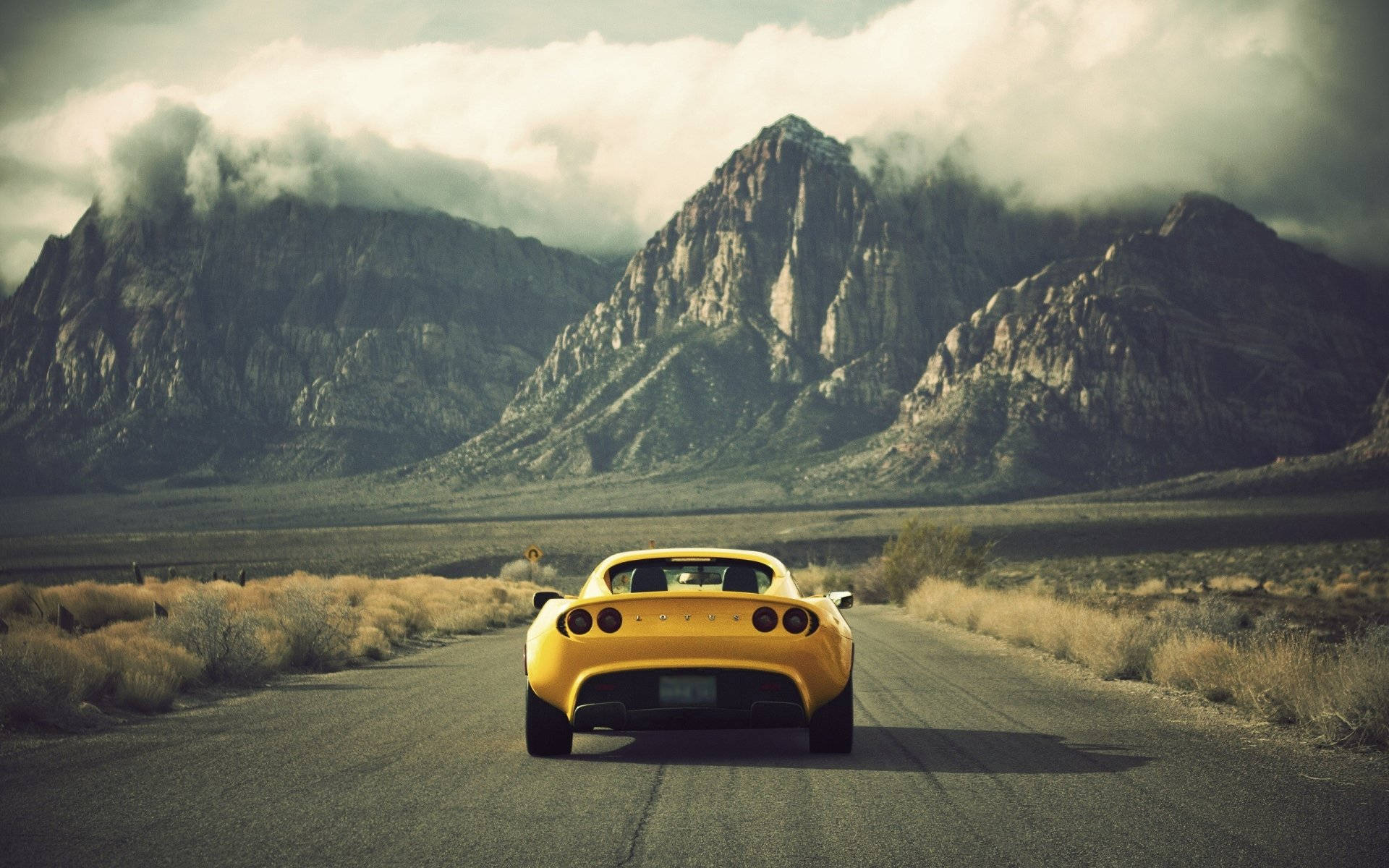 Effortless Power - Yellow Lotus Car Cruising Through The Arid Desert