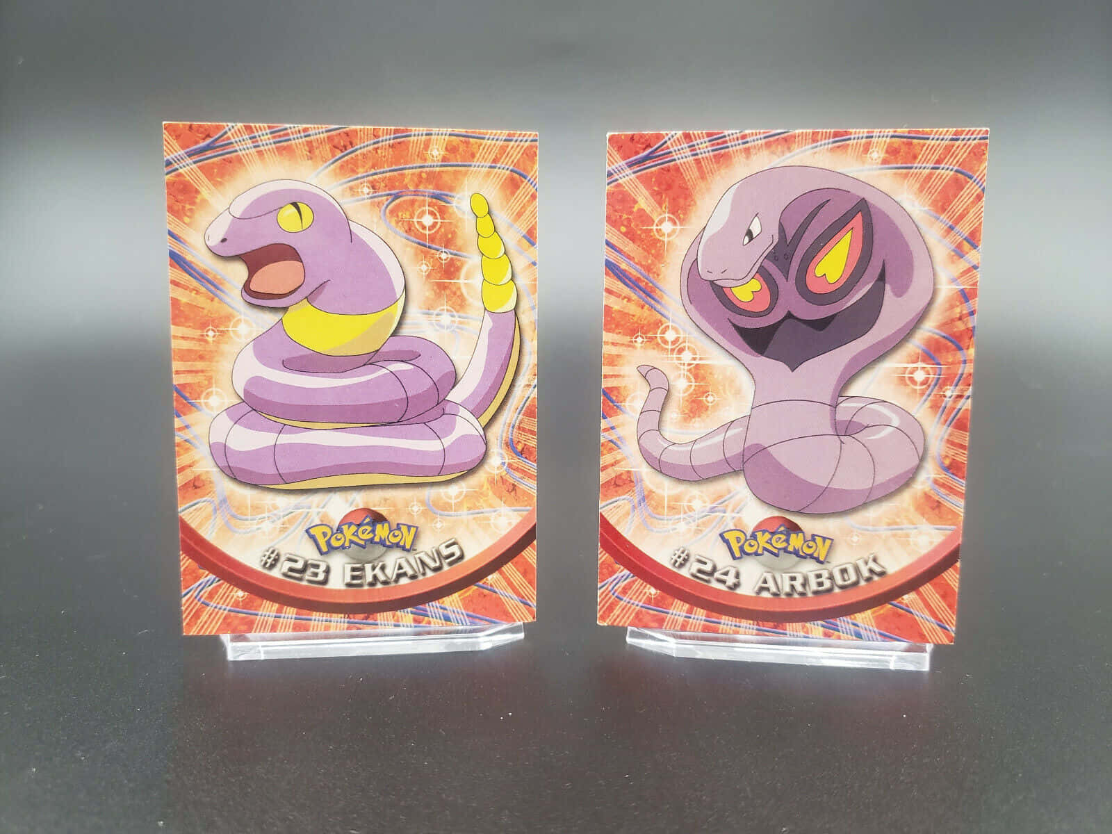Ekans And Arbok Cards On Blurry Gray Background