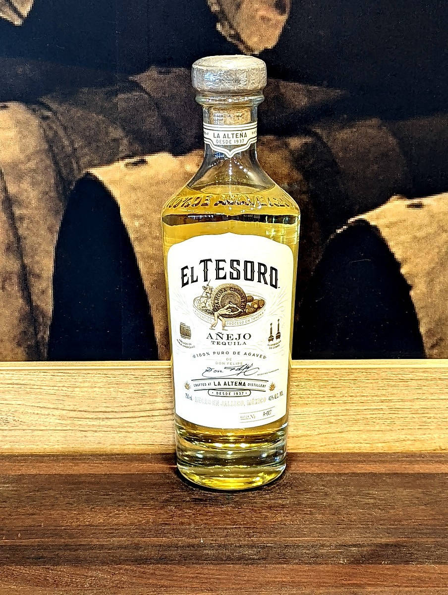 El Tesoro Añejo Gold Tequila Bottle Displayed On Rich Wooden Surface Background