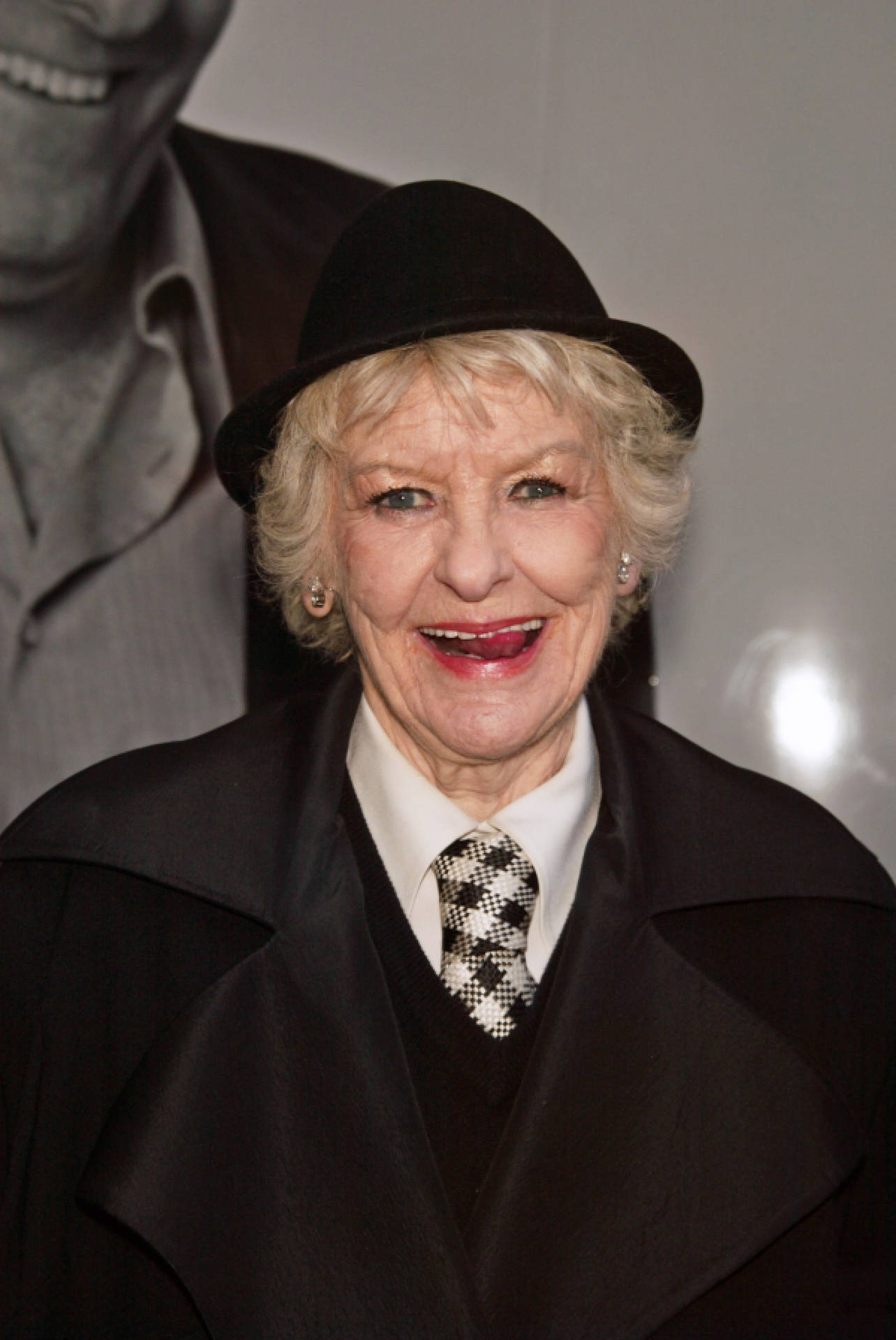 Elaine Stritch In Black Cap And Coat Background