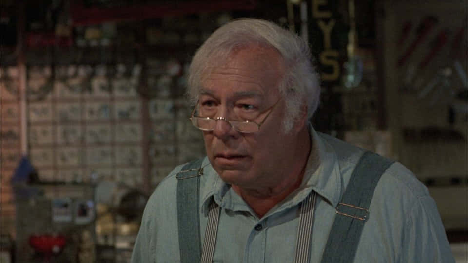 Elderly Actorin Blue Shirtand Suspenders Background