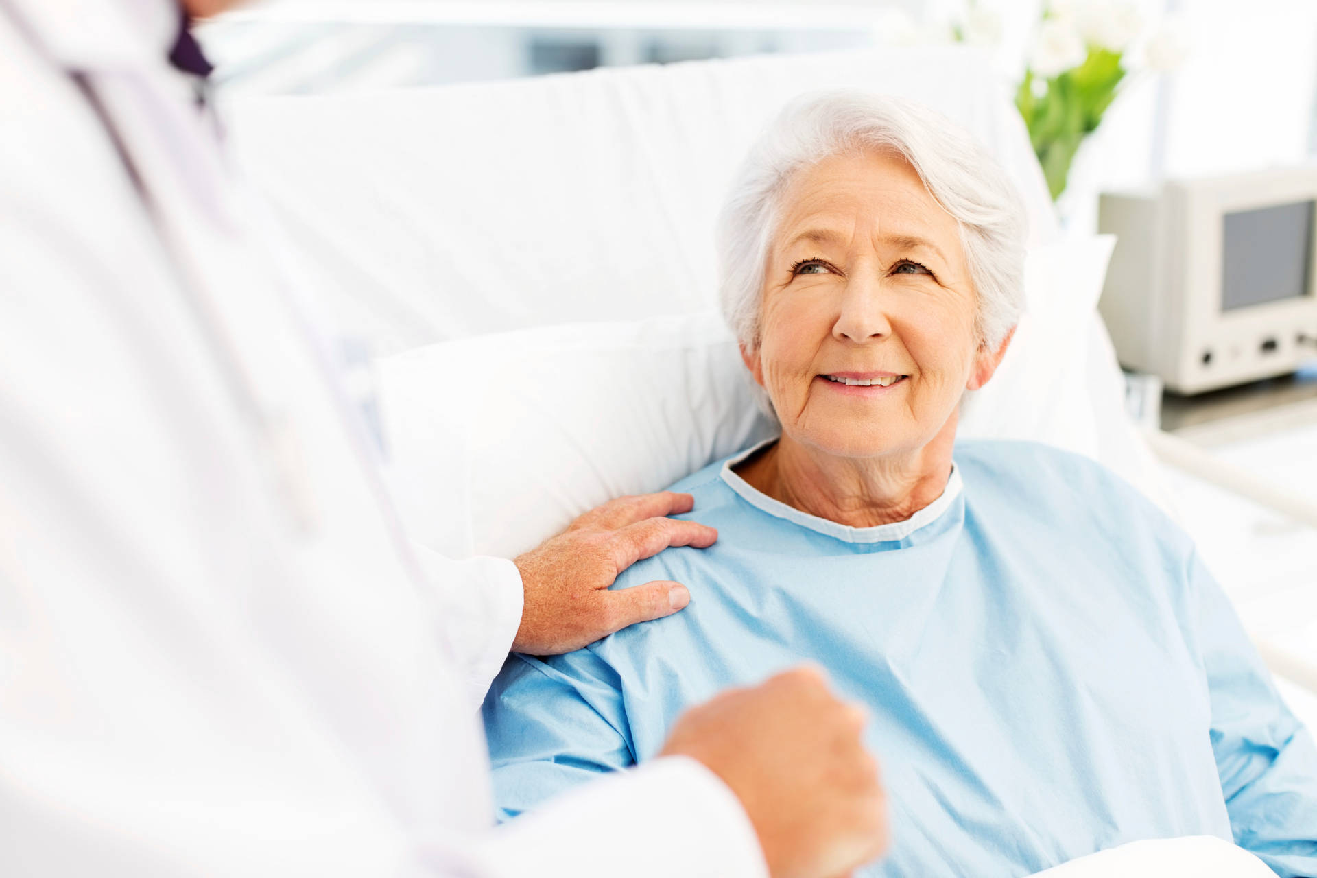 Elderly Female Patient Relaxing In Hospital Bed Background