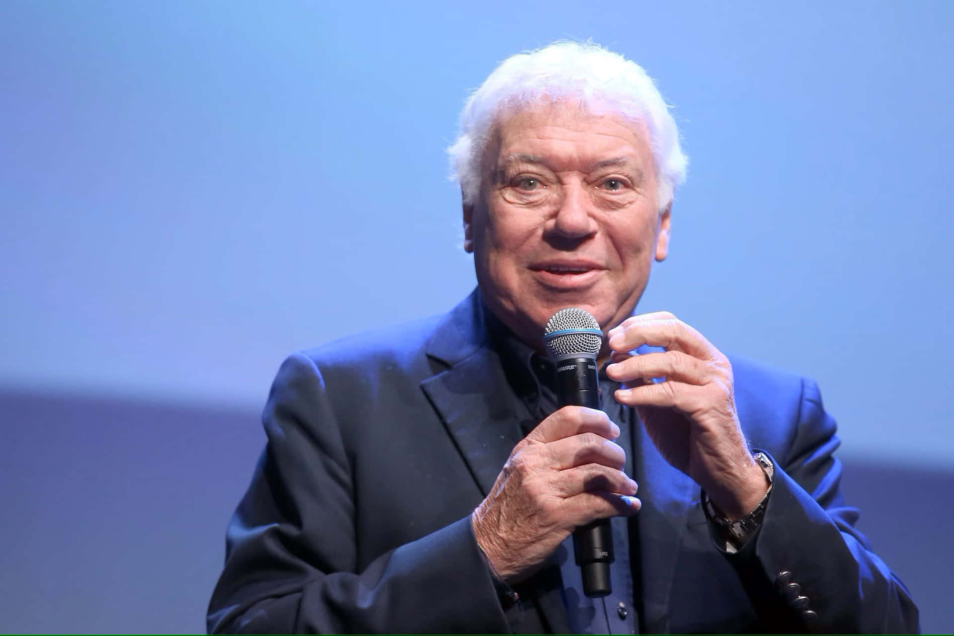 Elderly Man Speakingat Event.jpg Background