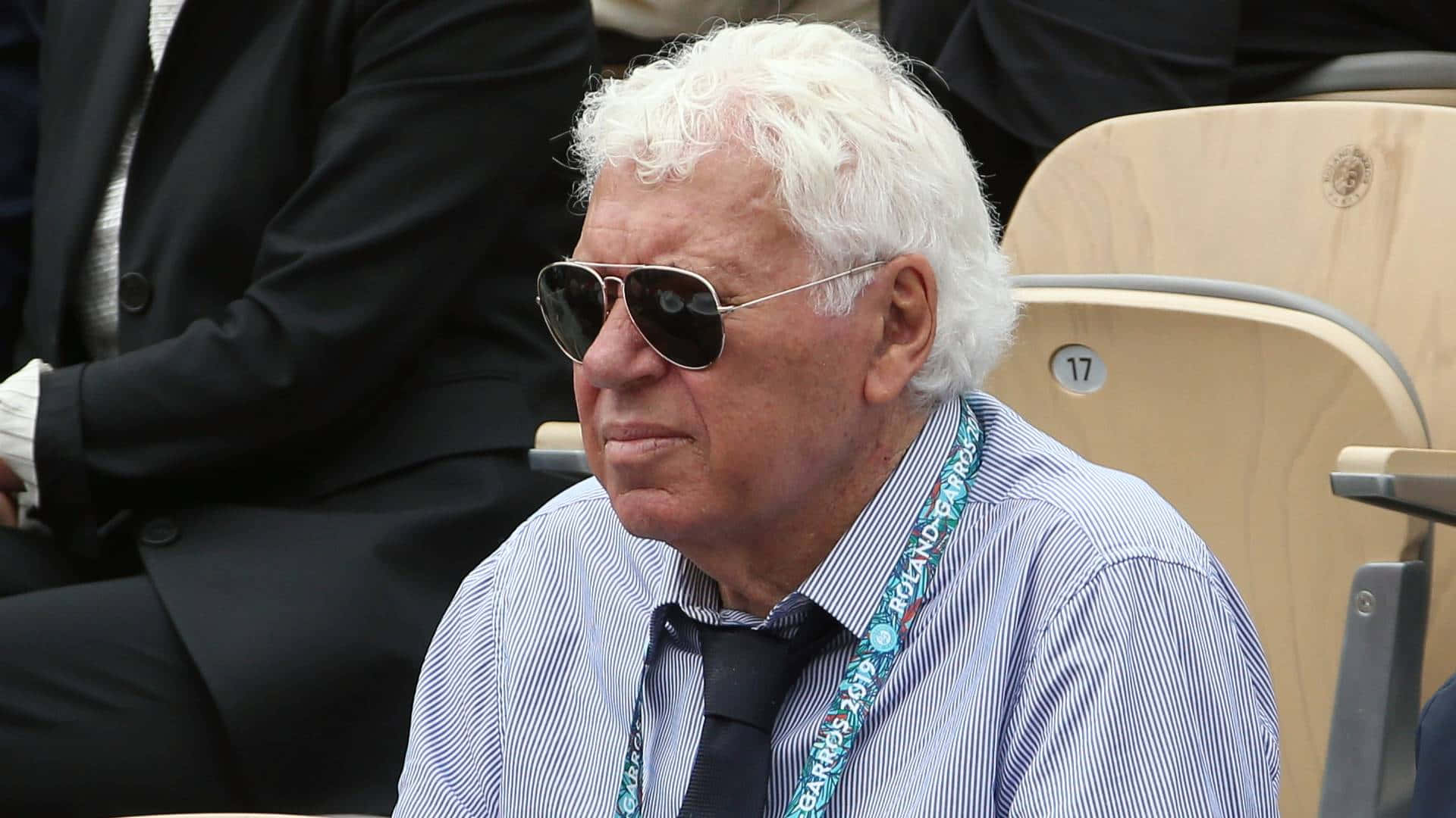 Elderly Man Wearing Sunglassesat Event Background
