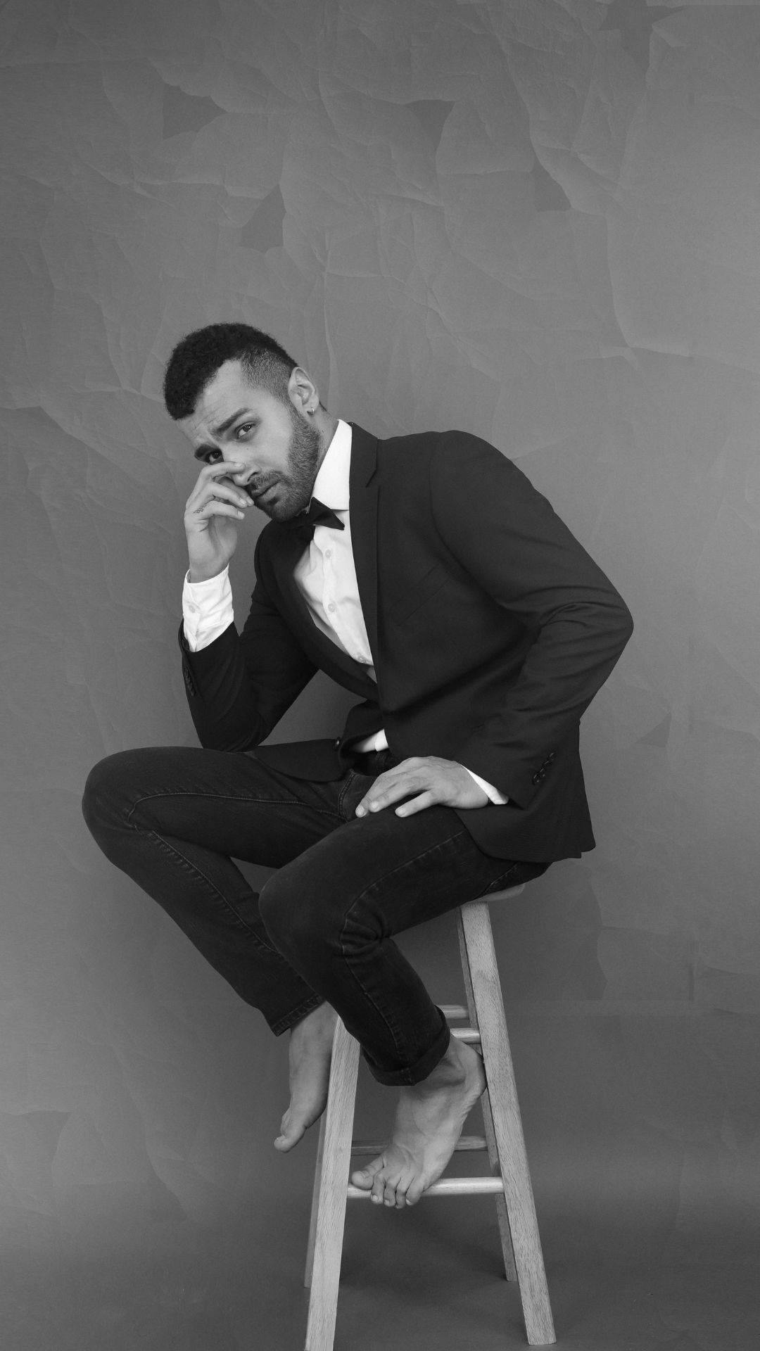 Elegance Defined: Man In A Black And White Formal Suit Background