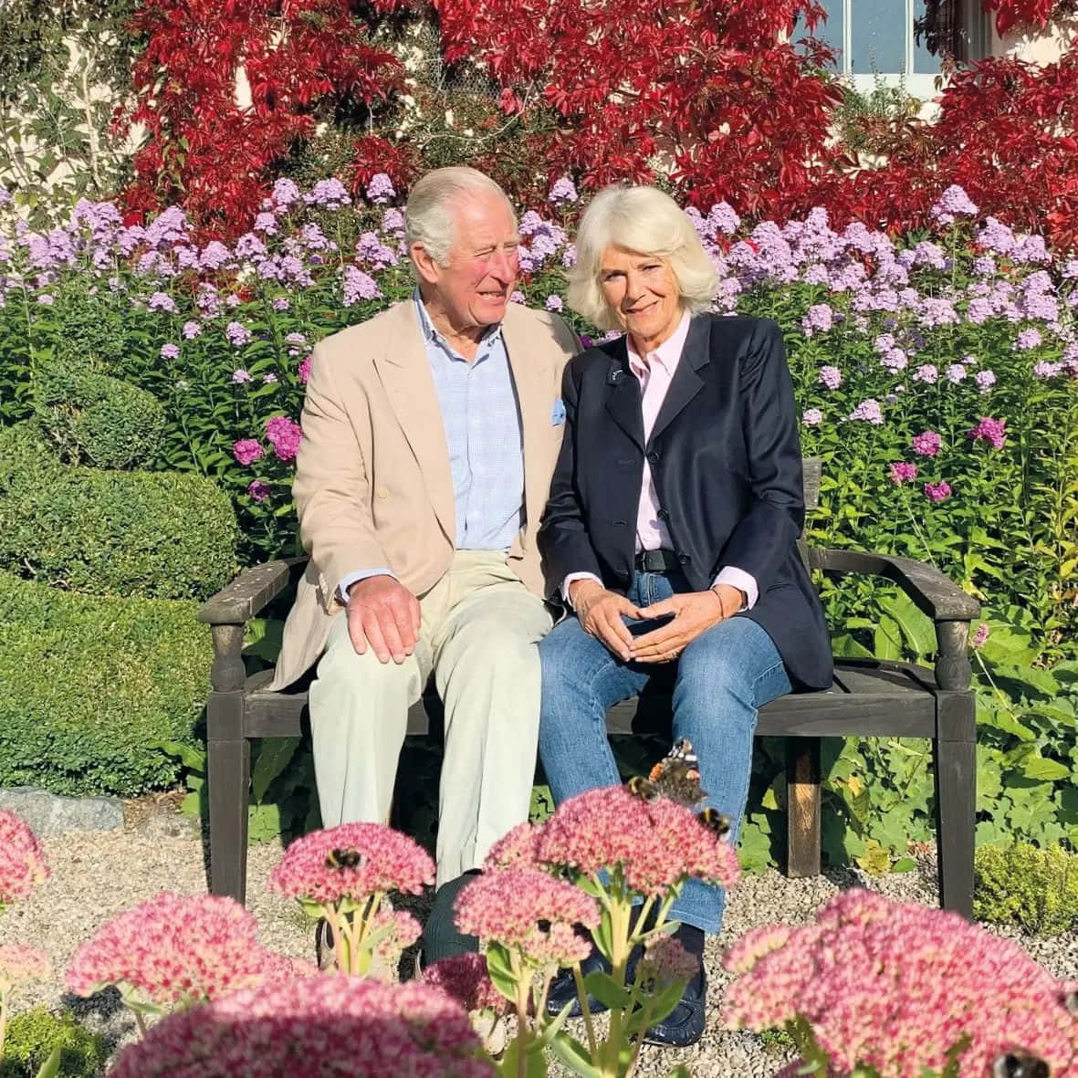 Elegance Embodied: Queen Camilla Poses Gracefully On Bench Background
