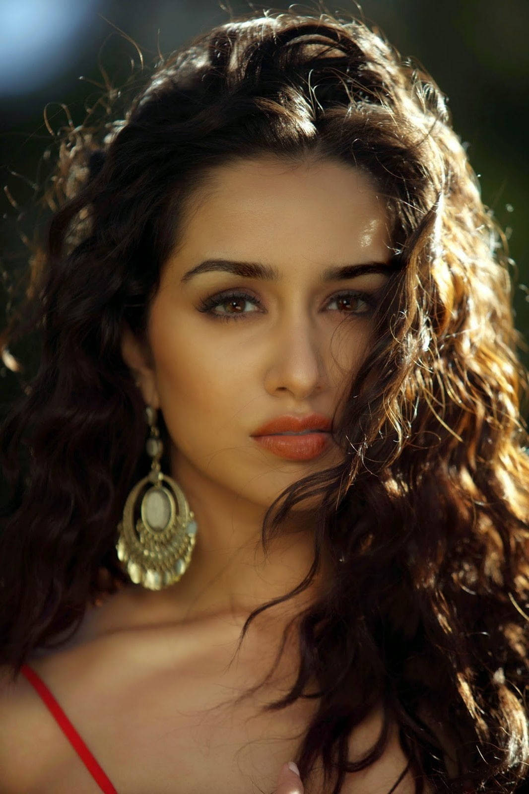 Elegance Personified - A Woman Flaunting Her Beautiful Curly Hair With Large Earrings. Background