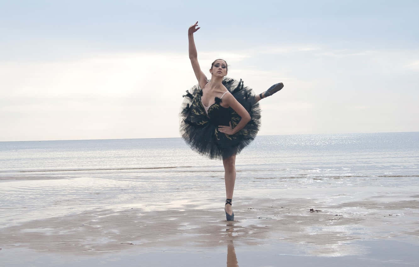 Elegant Ballerina In Motion Against A Dramatic Black Background Background