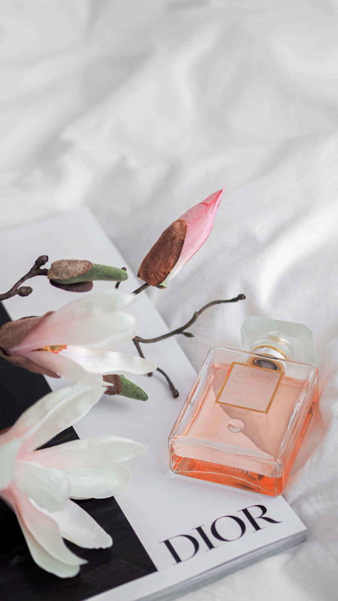Elegant Dior Perfume Bottle Floral Arrangement Background
