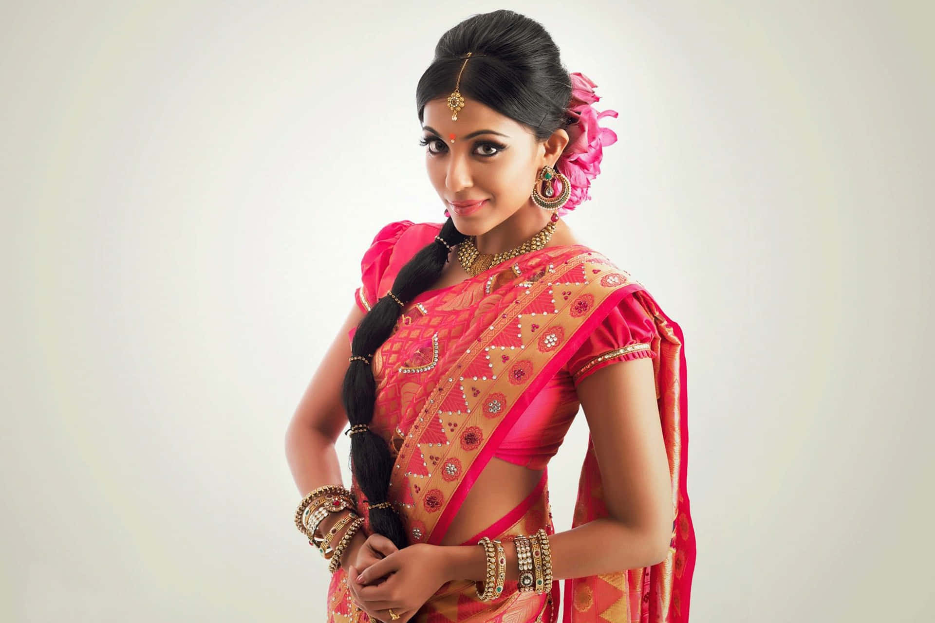 Elegant Indian Woman With Captivating Brown Eyes In A Pink Sari Background