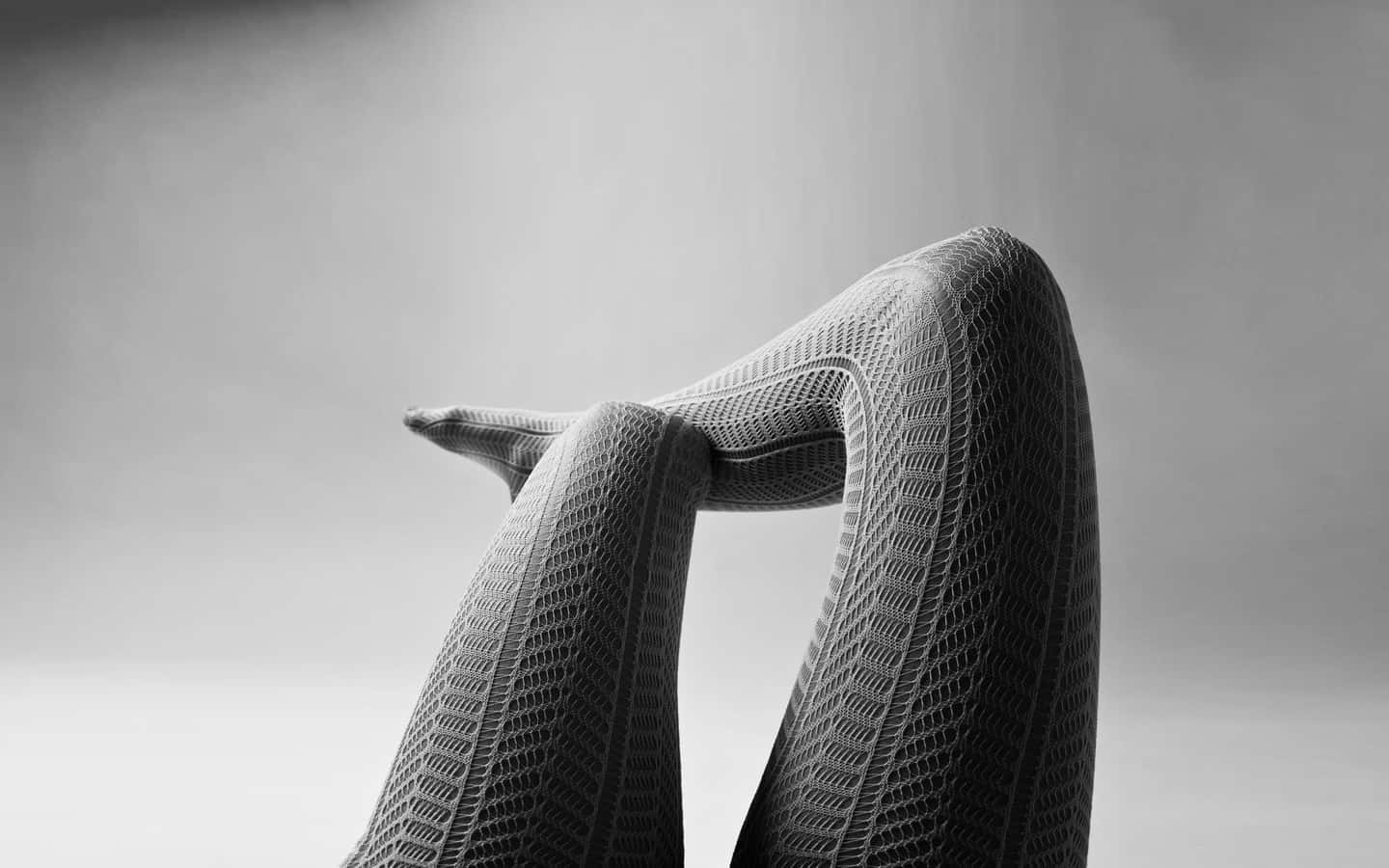 Elegant Legsin Fishnet Stockings Background