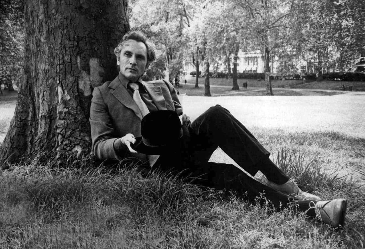 Elegant Man Leaning Against Tree Background