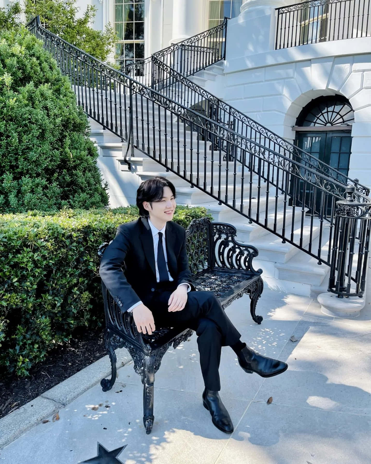 Elegant Man Seated Outdoor Staircase Background