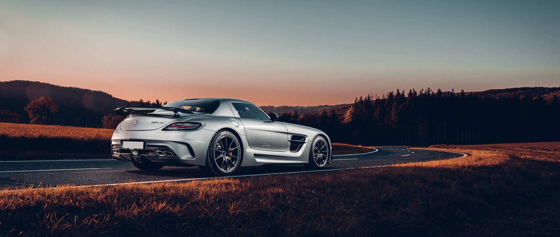 Elegant Mercedes Benz Amg Gliding Down The Highway Background