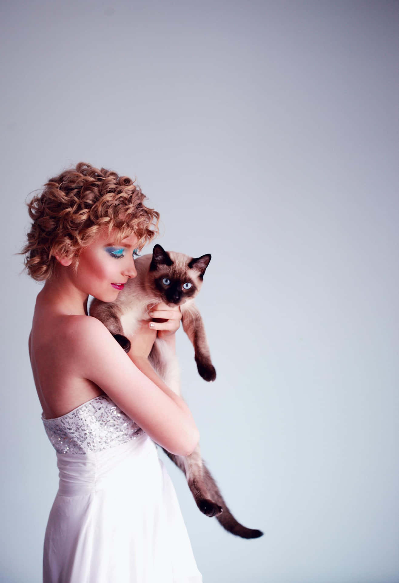 Elegant Woman Holding Siamese Cat Background