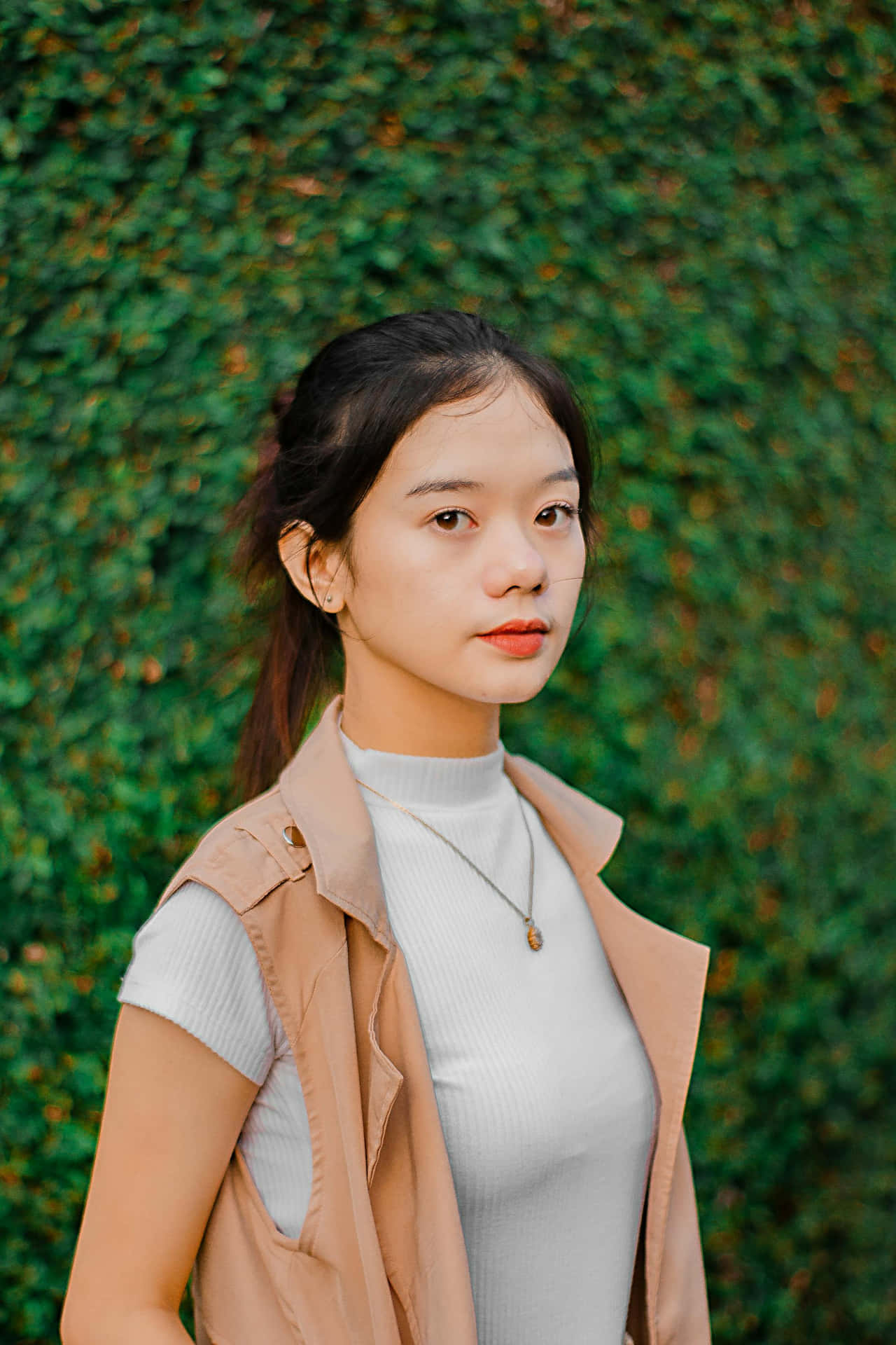 Elegant Young Woman Against Greenery Background