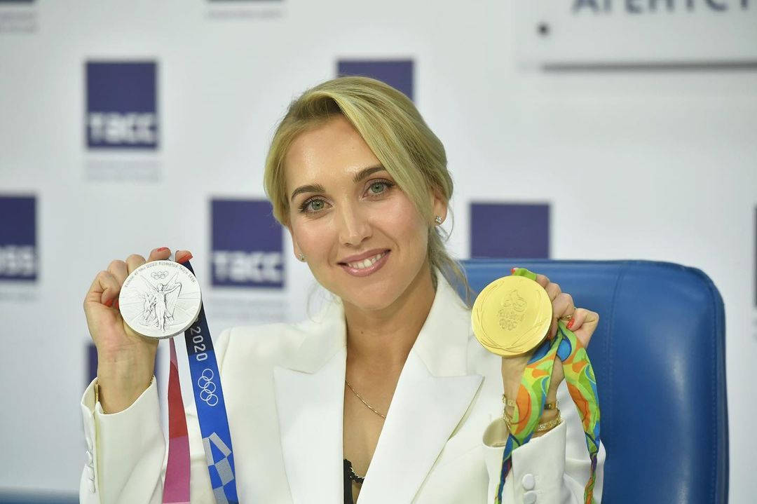 Elena Vesnina Holding Two Medals Background