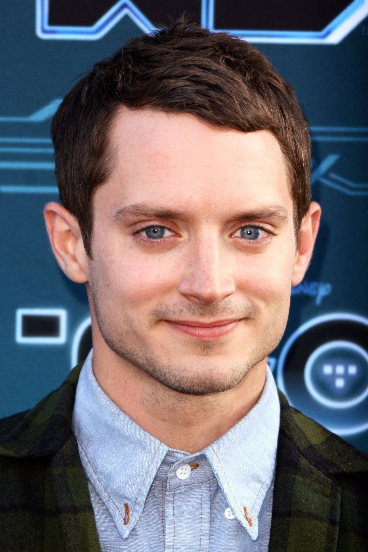 Elijah Wood Looking Stylish In Blue Denim Polo Background