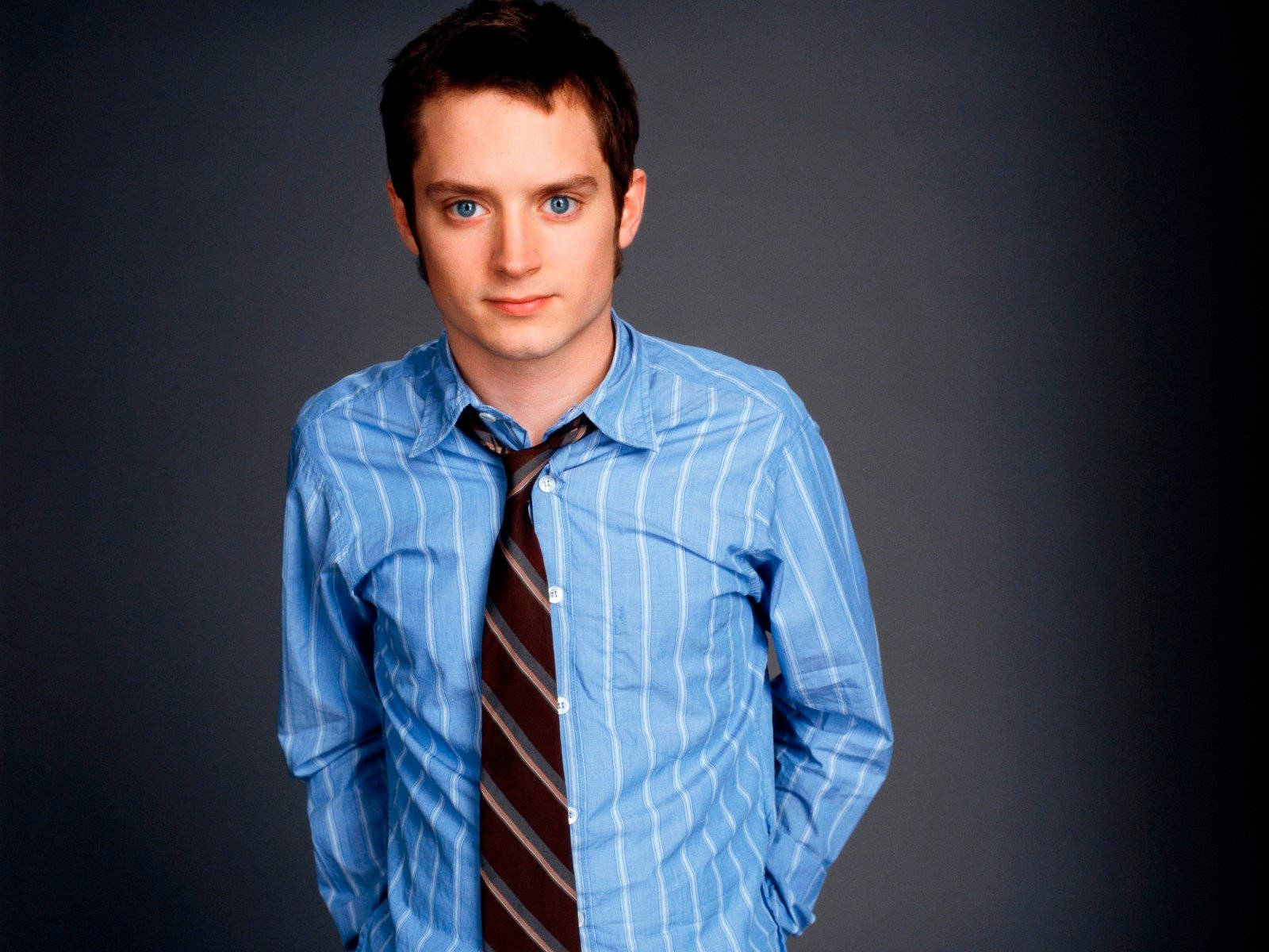 Elijah Wood Wearing Blue Stripe Shirt Background