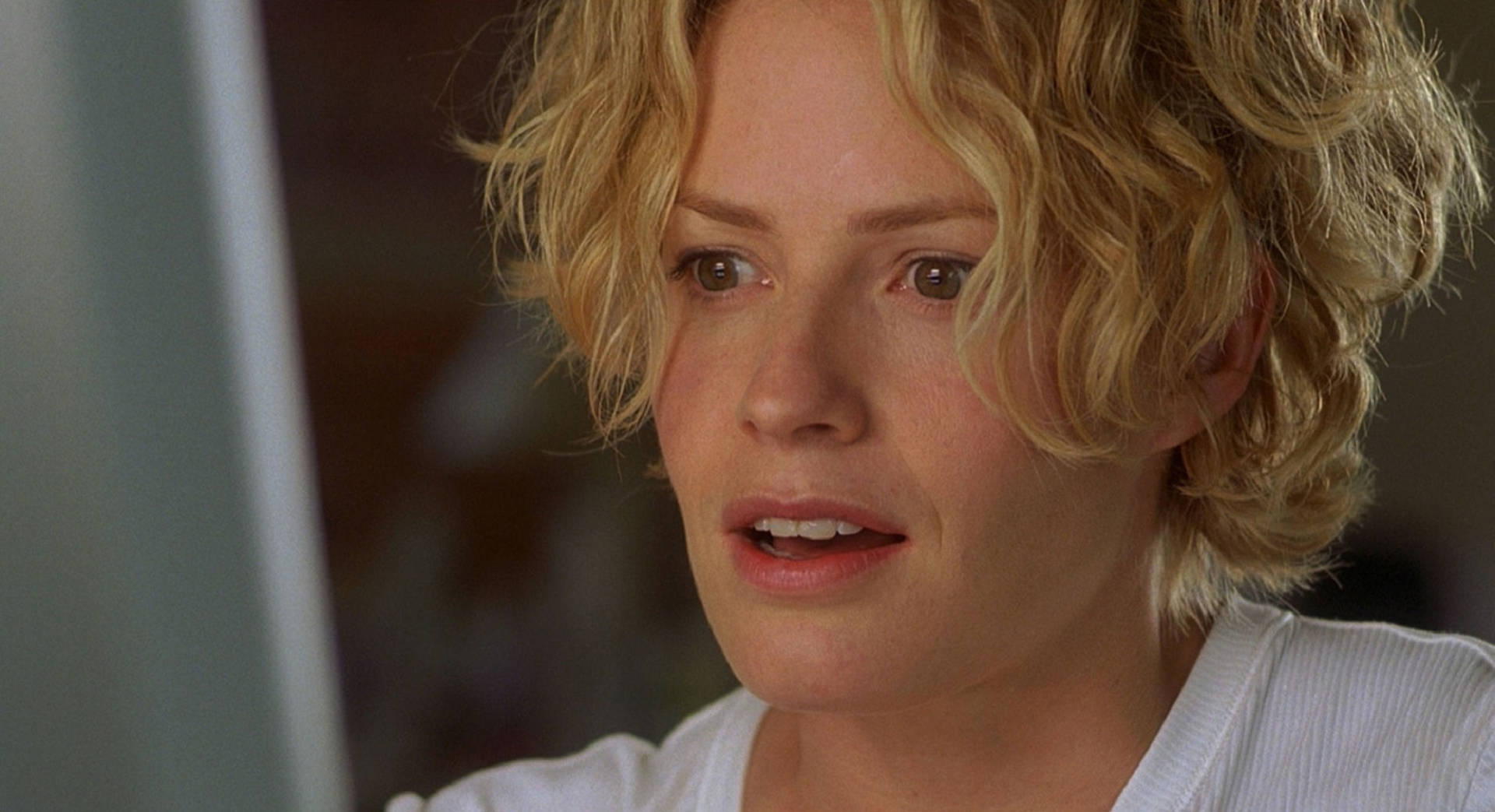 Elisabeth Shue With Short Blonde Curly Hair And Shocked Expression Background