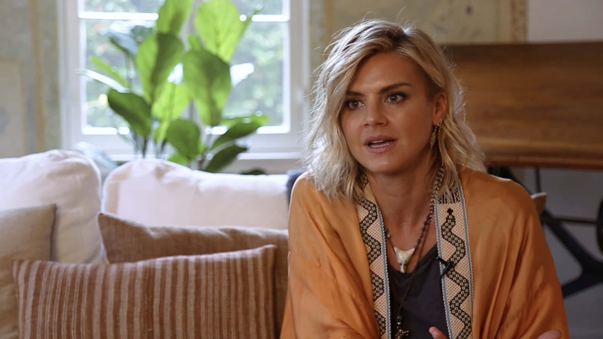 Eliza Coupe Striking A Pose In Front Of A Patterned Background