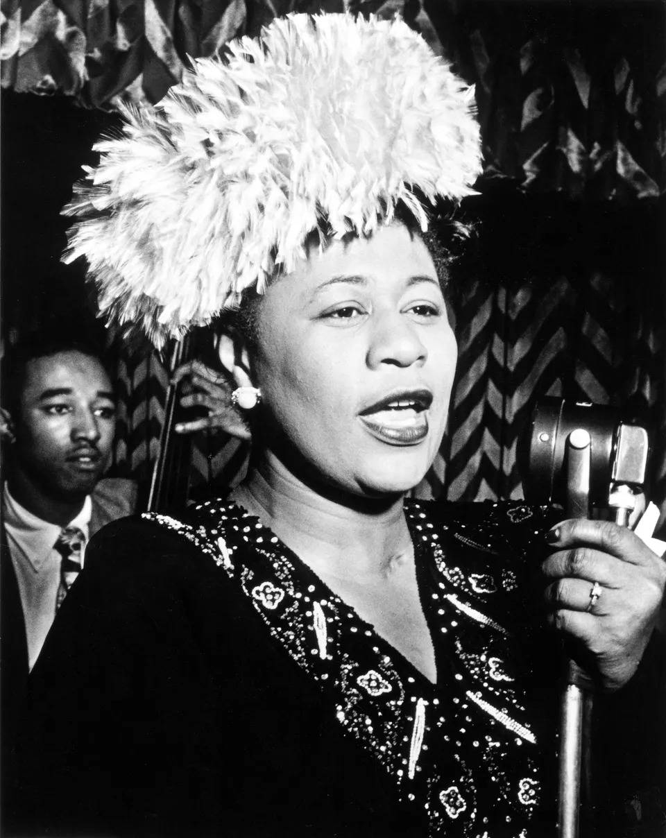 Ella Fitzgerald Holding A Microphone Background